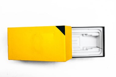 Açılmış sarı ve siyah renkli parlak paket, paket, mobil, ambalaj kutusu beyaz arkaplanda izole. Box mockup.Üst atış.