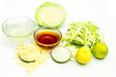 Beyaz üzerine izole edilmiş lahana maskeyi kapat. İçine biraz lahana ezmesi karıştırılmış yumurta, bal, pirinç tozu ve cilt iltihabı ve enfeksiyon önleyici limon koyulmuş bir kâse..