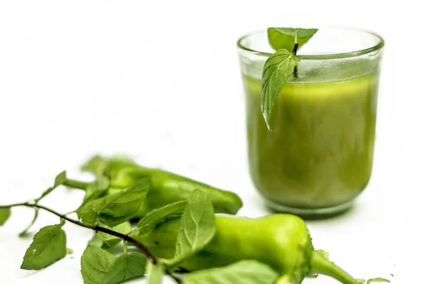 辛辣和甜的绿色辣椒汁在一个玻璃隔离 在白色表面的玻璃碗中 用新鲜的生绿辣椒及其果汁水平拍摄 — 图库照片