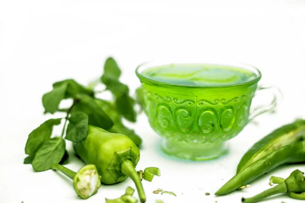近照一针生鲜辣椒 水平拍摄绿辣椒冰茶在玻璃杯与一些冰块在里面 被白色背景隔离 — 图库照片