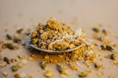 Sukhdi ya da Gropapdi ya da bazen kahverengi yüzey üzerindeki cam bir tabakta Hint şekerlemesi buğday unuyla karıştırılmış bir kıştır..