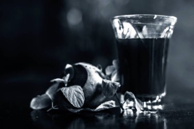 Sağlıklı pancar suyu, siyah parlak yüzeydeki bir bardakta kilo vermek için. Yanında biraz taze kesilmiş pancar kökü, biraz limon ve nane yaprakları. Arka planda bulanıklık olan yatay çekim..