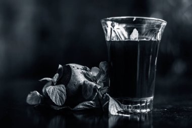 Sağlıklı pancar suyu, siyah parlak yüzeydeki bir bardakta kilo vermek için. Yanında biraz taze kesilmiş pancar kökü, biraz limon ve nane yaprakları. Arka planda bulanıklık olan yatay çekim..