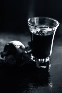 Sağlıklı pancar suyu, siyah parlak bir yüzey üzerindeki bir bardakta kilo vermek için biraz taze kesilmiş pancar kökü, biraz limon ve nane yaprağı. Arka planda bulanıklık olan dikey çekim..