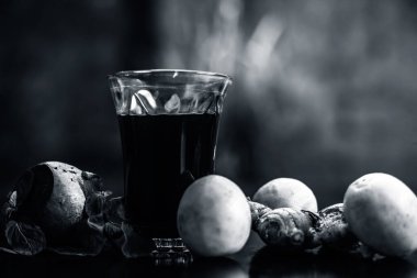 Biraz nane aromalı pancar suyu limon suyu ve zencefil ile siyah parlak bir yüzey üzerinde kilo vermek için bir bardak içinde. Bokeh arkaplanlı yatay çekim.