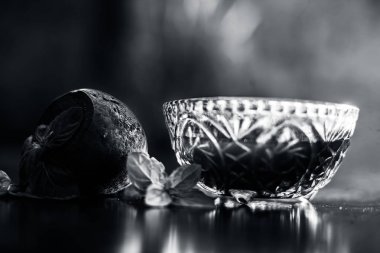 Böbrek iltihabına çare olarak kullanılan çiğ taze pancar pancarı sebzesiyle siyah parlak bir yüzey üzerinde cam bir kasede çıkarılmış pancar tentürü. Yatay çekim.