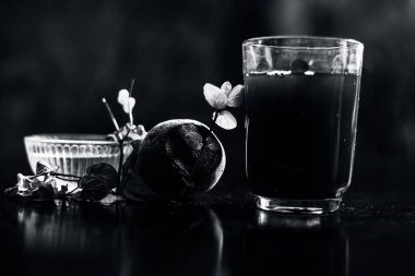 Siyah parlak bir yüzeyde, üzerinde taze nane yaprakları ve su olan pancar püresi. Nane yaprağıyla birlikte yatay pancar püresi. Bulanık arkaplan ile çekim.