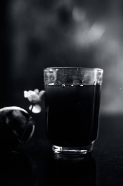 Siyah parlak bir yüzeyde, üzerinde taze nane yaprakları ve su olan pancar püresi. Nane yaprağıyla birlikte yatay pancar püresi. Bulanık arkaplan ile çekim.