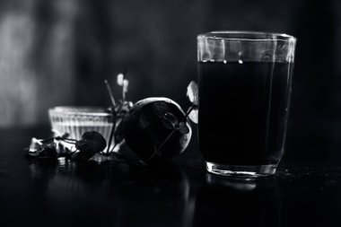 Siyah parlak bir yüzeyde, üzerinde taze nane yaprakları ve su olan pancar püresi. Nane yaprağıyla birlikte yatay pancar püresi. Bulanık arkaplan ile çekim.