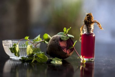  beetroot along with some mint leaves and its extracted detoxifying essential oil in a tiny glass bottle.Horizontal shot with blurred background. clipart