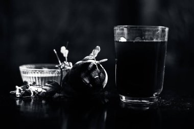 Siyah parlak bir yüzeyde, üzerinde taze nane yaprakları ve su olan pancar püresi. Nane yaprağıyla birlikte yatay pancar püresi. Bulanık arkaplan ile çekim.