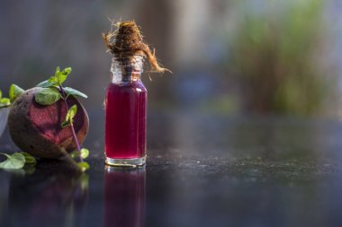 beetroot along with some mint leaves and its extracted detoxifying essential oil in a tiny glass bottle.Horizontal shot with blurred background. clipart
