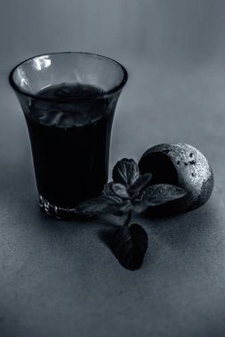 Kahverengi yüzeyde bir bardakta taze pancar suyu ve yanında taze kesilmiş sebze. Yüksek açılı dikey atış..