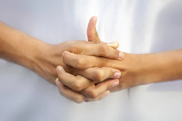 Isolated interlace fingers of both hands and extending up one finger forming Linga Yoga mudra on white background. Horizontal shot.