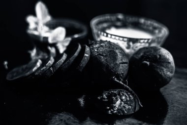 Siyah parlak yüzey üzerinde pancar maskesi rendelenmiş pancar sebzesi ve ekşi kremadan oluşan cam bir kâseye karıştırılmış çiğ kesilmiş pancar kökü sebze ve kremayla birlikte..
