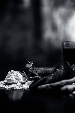 Siyah parlak yüzeyde pancar suyu, gram / nohut unu, zerdeçal veya Haldi ve sütten oluşan pancar maskesi. Bu kapsamlı bir pancar maskesi. Dikey çekim.