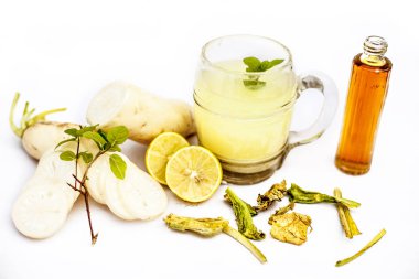 Beyaz arka planda izole edilmiş cam bardaktaki Daikon yeşil çayının yakın plan görüntüsü taze dilimlenmiş daikon veya beyaz turp ile birlikte..