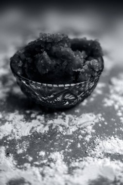 Hint Gujarati 'sinin popüler yemeği Atte ka sheera ya da Halwa-Karah parshad' ı kahverengi bir yüzeye serpiştirilmiş buğday unuyla birlikte cam bir kaseye koy. Dikey çekim.