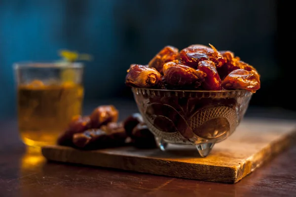 Close up of raw dates along with its syrup in a glass with some mint leaves on it which helps in weight loss, constipation aid and promotes heart health. Horizontal shot with blurred background.