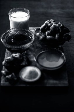 Tarihler, kahverengi ahşap bir yüzeyde altın bir ışık ve bazı hurma, süt, irmik ve bal içeren seçici bir odak noktasıyla yüz maskesi takıyor. Yumuşak ve parlak cilt için. Dikey çekim.