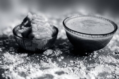 Hint Dili Kış Suyu 'na yakın olan Bajri Rabb' ın kış içeceğini ya da Bajri ki rabdi / rabri 'yi cam bir kasede, çiğ inci darı unu ve jaggery ile birlikte iç. Kahverengi ahşap bir yüzeyde.