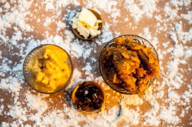 Hint Gujarati popüler yemeği Atte ka sheera ya da Halwa-Karah parshad kahverengi bir yüzey üzerinde biraz buğday unu, jaggery, ghee ya da netleştirilmiş tereyağı ve mira hirabol veya heerabol ile cam bir kasede..