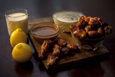 Hurmalar, cam bir kasede kışın kuru cilt için yüz maskesi, biraz hurma, süt limon suyu ve nemlendirici krem içeriyor. Bütün malzemelerle yüz maskesi ve çiğ tarihler. Yatay çekim..