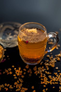 Özel gond katria yaz içeceği, içinde biraz karabiber ve limon suyu olan ahşap bir yüzey üzerinde cam bir bardakta. Yanında da yayılmış gond, sakız, yenilebilir sakız kristalleri..