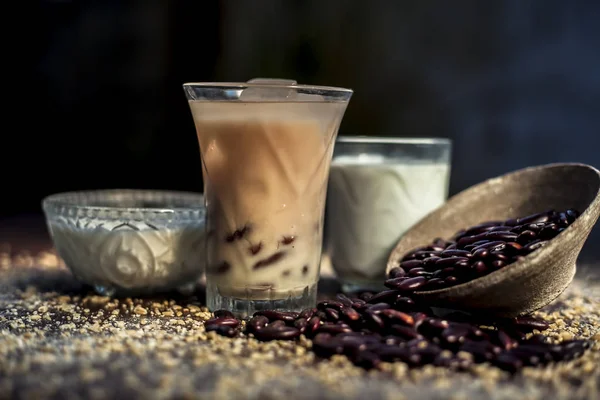 Red bean smoothie or kidney beans smoothie in a glass along with some red bean paste, banana, yogurt, milk, oatmeal, and ice cubes rich in protein. Horizontal shot.