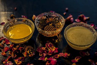 Ayurvedic moisturizer face mask on black glossy surface in a glass bowl with some ghee or clarified butter, honey and pack. clipart