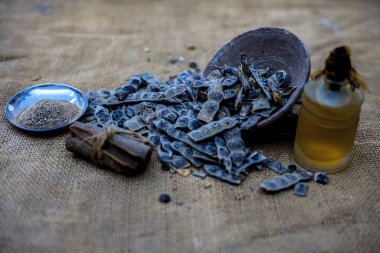 Topçu çantasının yüzeyindeki ayurvedik babun diş macunu için gerekli malzemeler: tarçın çubuğu, temel yağ, kabartma tozu ve babun tozu..