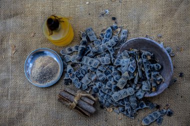 Topçu çantasının yüzeyindeki ayurvedik babun diş macunu için gerekli malzemeler: tarçın çubuğu, temel yağ, kabartma tozu ve babun tozu..