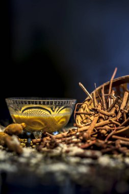 Ayurvedik kan temizleyici ve manjistha, mung fasülyesi, haldi / zerdeçal ve sütten oluşan cilt parlatıcı yüz maskesi. Siyah bir yüzey üzerinde tüm bileşenleriyle yüz maskesinin yatay görüntüsü.