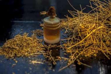 Ayurvedic hafıza güçlendirici ot shankhpulpi ya da Convolvulus pluricaulis kökleri ile birlikte siyah ahşap bir yüzey üzerinde seçici odaklı ve bulanık arkaplan ile yakın çekim.