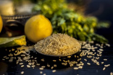 Bunch of coriander leaves, honey, lemon, rice, milk and aloe vera gel face mask for all the skin types and for natural face glow on a black wooden surface. Horizontal shot.