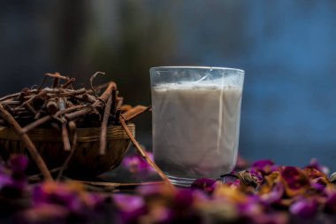 Face mask of manjistha or Indin madder root on a black wooden surface consisting of manjistha roots powder, lemon, milk and some essential rose oil. Face mask used for minor skin infections and acne.