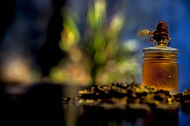 Close up of shankhpushpi roots on the wooden surface along with some of its powder and oil with it. Shot with blurred background. Horizontal shot.