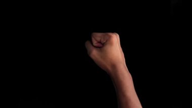 Karanlık arka planda el hareketlerinin yakın çekimi, izole edilmiş