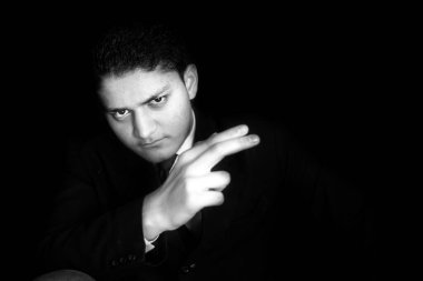 Mavi takım elbiseli ve elinde bir şey tutan zengin bir adamın portre resmi siyah bir arka planda izole edilmiş bir Don 'un yüz ifadesini yayıyor..