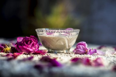 Taze krema ve buğday unundan oluşan bir tahtanın üzerinde cilt beyazlaması için yüz maskesi. Biraz ısı unu ve gül yapraklarıyla bir kase krema. Yatay çekim.