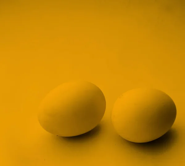 Nahaufnahme Von Zwei Eiern Gelb Gefärbt Auf Gelbem Hintergrund Isoliert — Stockfoto