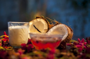 Hindistan cevizi sütü maskesi morötesi ışığa karşı korunmak için kahverengi renkli bir yüzey üzerinde biraz gül suyu ve hindistan cevizi sütü içerir. Yüzeydeki tüm malzemelerin fotoğrafı..;