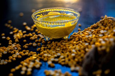 Siyah yüzeyde cam bir kasede taze haşlanmış nohut ezmesi ve çiğ nohut mercimeği..