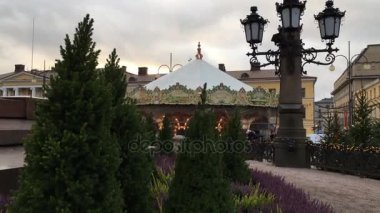 Finlandiya, Helsinki, 9 Aralık 2017. Noel atmosferi Meydanı, çam köknar, Mazı, Heather, küçük Noel ağaçları peri ışıkları, güçlü bir sokak lambası, çocukların atlıkarınca, insanların hareket ile dekore edilmiş