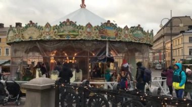 Finlandiya, Helsinki, 9 Aralık 2017. Senato Meydanı, yanıp sönen ışıklar, çocukları yürüyüş sadece turistler için bekleyen anne Noel atlıkarınca çocuk binmek 