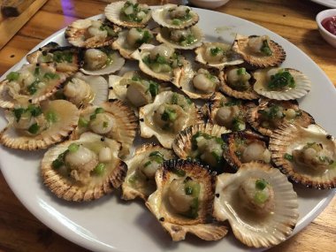 plaka üzerinde birçok lezzetli tarak kızarmış, Shell, soğan, deniz ürünleri, egzotik yiyecek ile serpilir