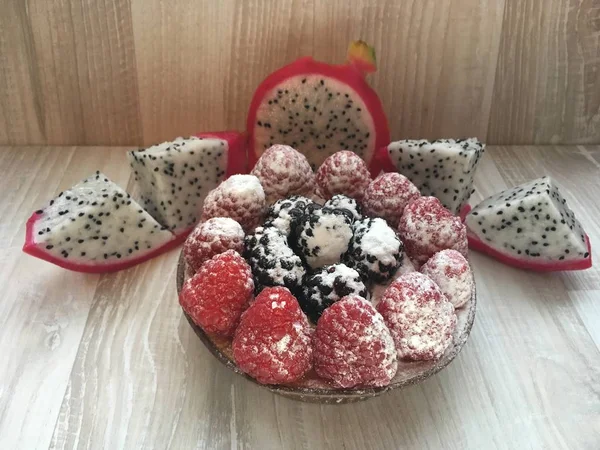 Kompozisyon meyve sepeti, ahududu, böğürtlen, pudra, lezzetli güzel pasta, pitahaya meyve daha sonra siyah tohumları ile beyaz