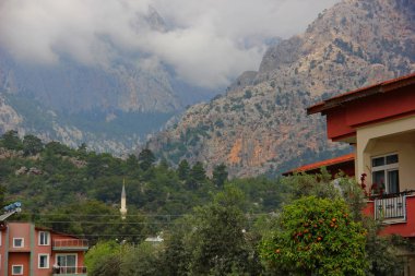 özel evler bulunan bulutlar aşağı Dağları'nın eteklerinde bahçesinde büyüyen portakal ağacı meyve ile görünür spire caminin Güney bölgelerinde, Türkiye