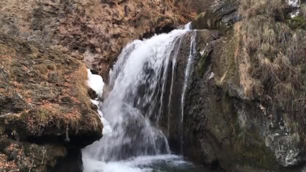 chute d'eau avec une bonne pression d'eau coule des montagnes, rochers, fin de l'automne, herbe jaunie, un beau phénomène naturel 