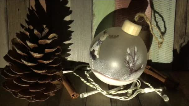 半透明のボール クリスマスのおもちゃをぶら下げ 点滅するガーランドの横にあり ライトをオンとオフにし 内側のボールを強調し シナモンスティック 大きな松のコーン お祝いの雰囲気 — ストック動画